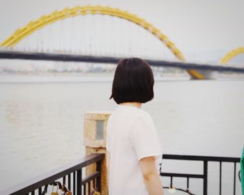 Woman standing by river in city