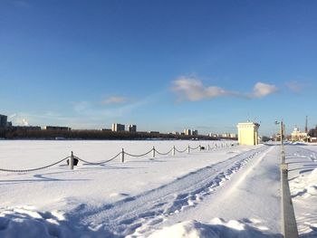 Snow covered field against blue sky