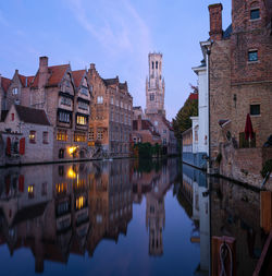 Canal amidst buildings against sky in city