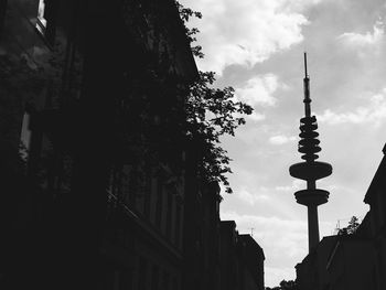 Communications tower against cloudy sky