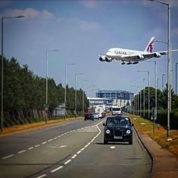 Cars on road against sky in city