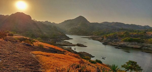 Scenic view of river and mountains against sky