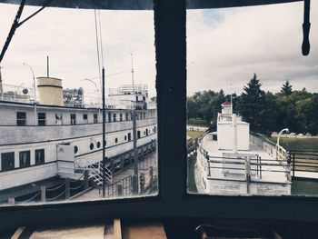 High angle view of buildings against sky seen through glass window
