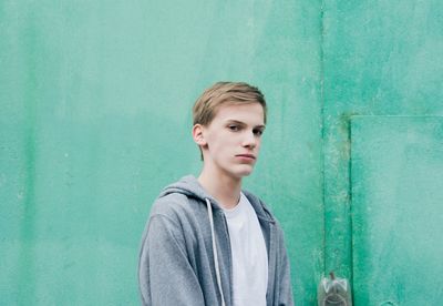 Portrait of boy standing against wall