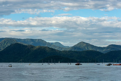 Scenic view of sea and mountains against sky