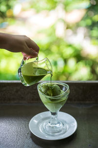 Cropped hand pouring water in glass