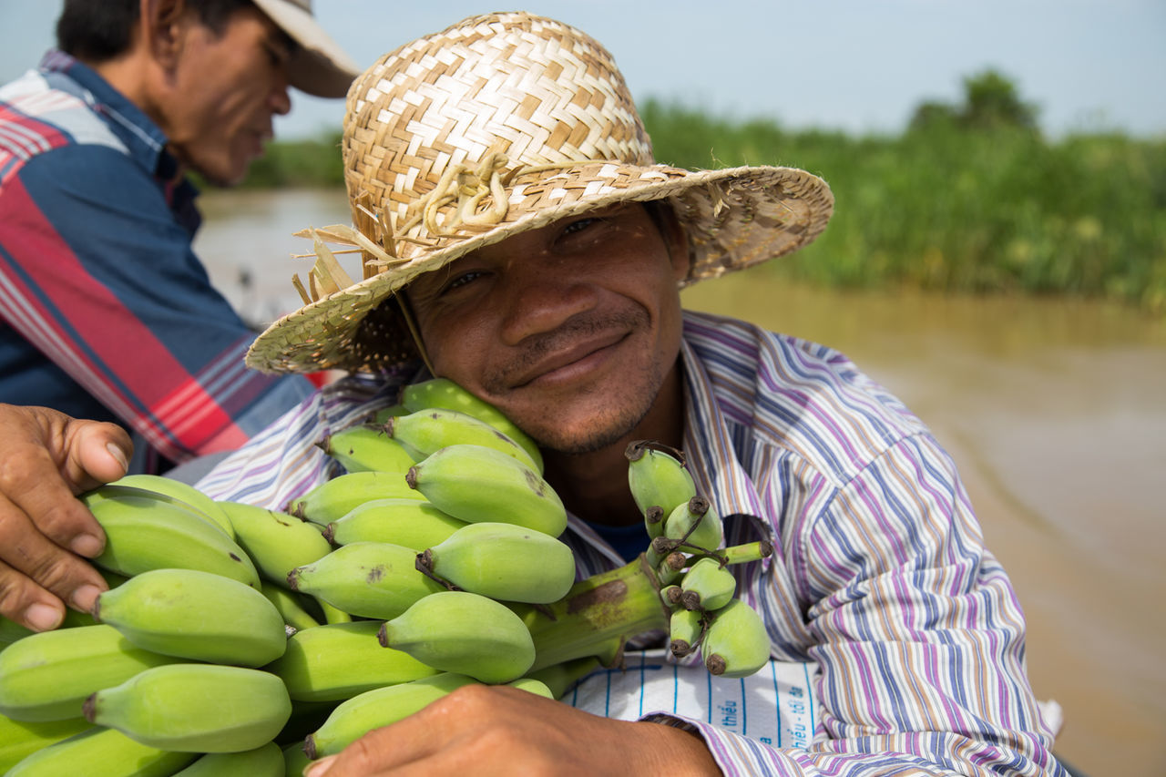 CLOSE-UP OF MAN SITTING ON FRUIT