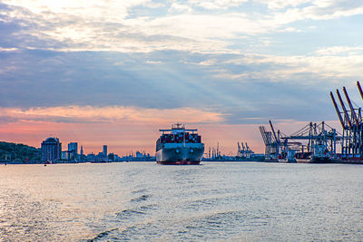 Boats in sea at sunset