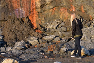 Side view of a woman standing on rock