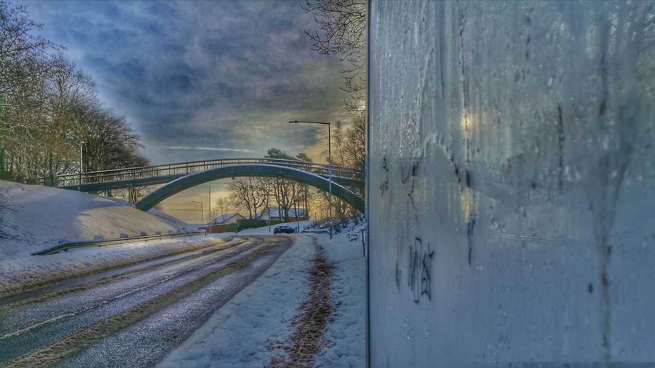 ROAD BY SNOW COVERED BRIDGE