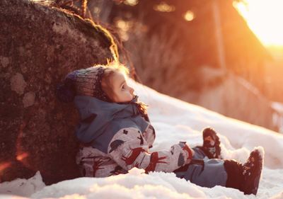 Rear view of women sitting on snow during winter