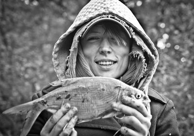 A smiling girl holding a freshly caught fish