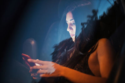 Young woman using smart phone while sitting in car