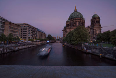 Blurred motion of ferry sailing over spree river by berlin cathedral