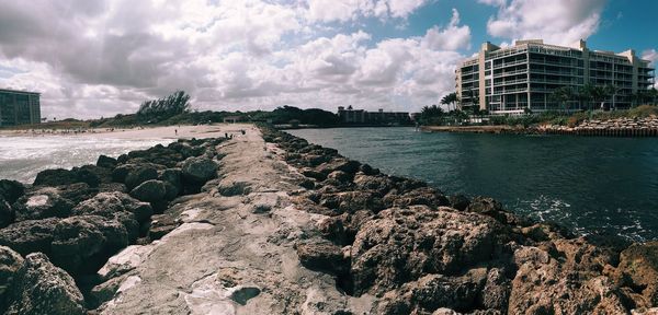 Scenic view of beach against cloudy sky