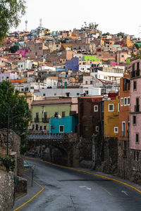 Road amidst buildings in town against sky