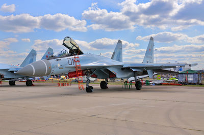 Airplane on airport runway against sky