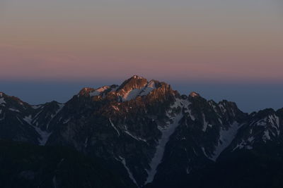 Scenic view of snowcapped mountains against sky during sunrise