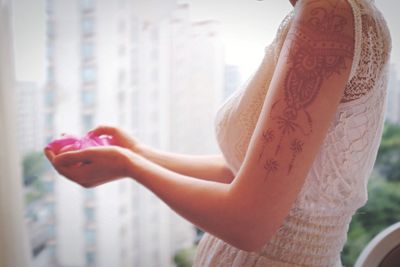 Side view of woman with henna tattoo on hand