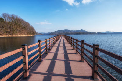 Pier over lake against sky