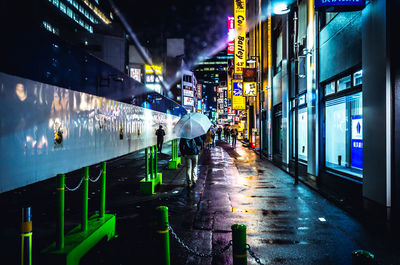 Wet street amidst buildings in city during rainy season