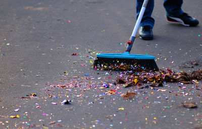 Low section of man sweeping street