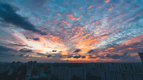 Aerial view of city against dramatic sky
