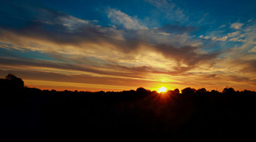 Silhouette landscape against scenic sky