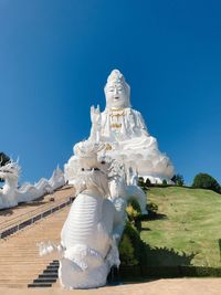 Low angle view of statue against blue sky