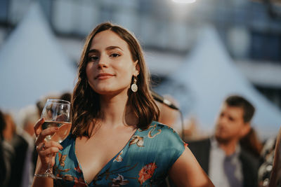 Portrait of a beautiful young woman drinking glass