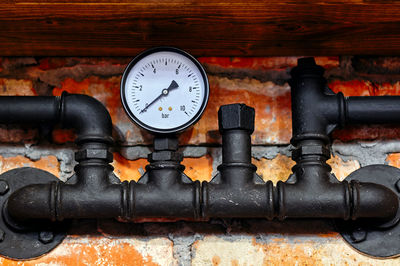 Low angle view of gauge on brick wall