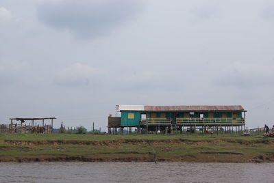 Building by lake against sky