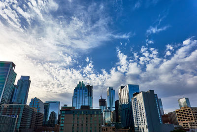 Modern buildings in city against dramatic sky