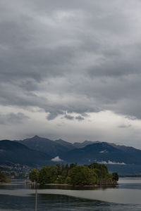 Scenic view of river by mountains against sky