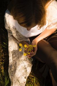 Midsection of woman with flower bouquet against plants