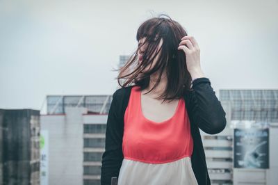 Beautiful woman standing against building in city