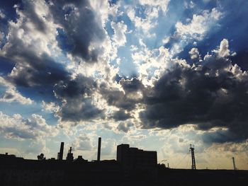 Silhouette building against cloudy sky