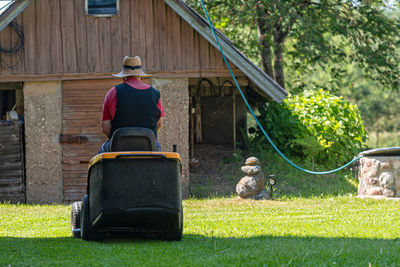 Rear view of man in yard against building