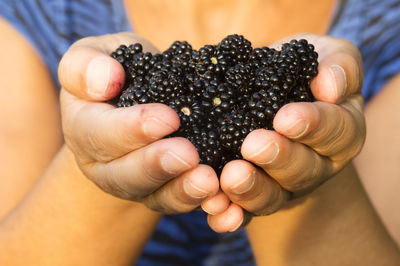 Midsection of mid adult woman holding mulberries