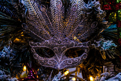 Close-up of mask on illuminated christmas tree