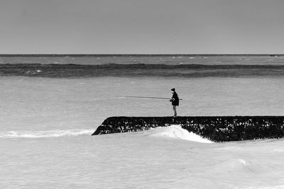 Man standing on shore at beach