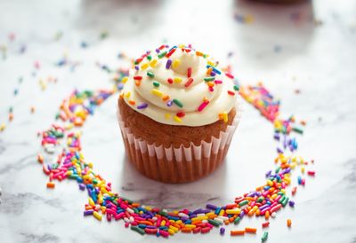 High angle view of cupcake and sprinkles on table