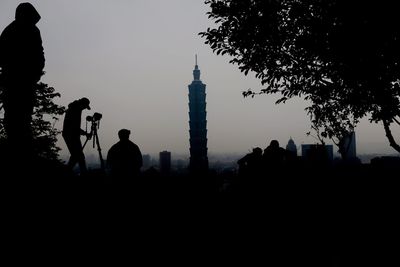 Silhouette of woman against sky at sunset