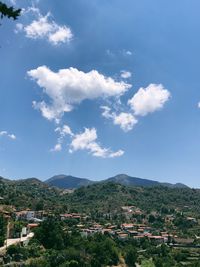 Scenic view of town by mountains against sky