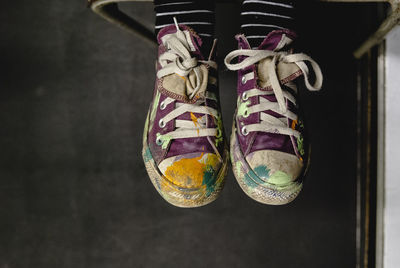 Low section of person wearing messy canvas shoes