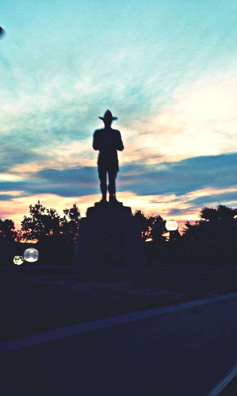 sky, statue, sculpture, human representation, art and craft, art, cloud - sky, silhouette, sunset, creativity, tree, dusk, cloud, cloudy, low angle view, road, animal representation, illuminated, street