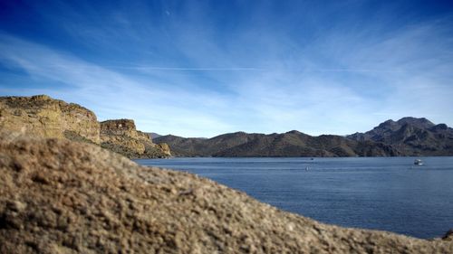 Scenic view of lake and mountains against blue sky