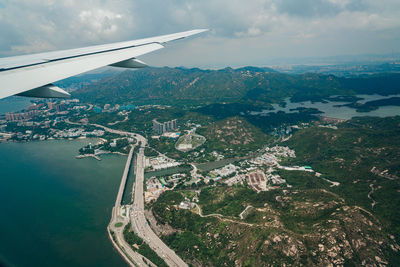 Aerial view of airplane flying over water against sky