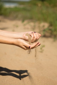 Midsection of woman hand on sand