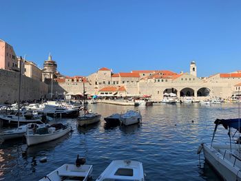 Boats moored in canal by buildings in city